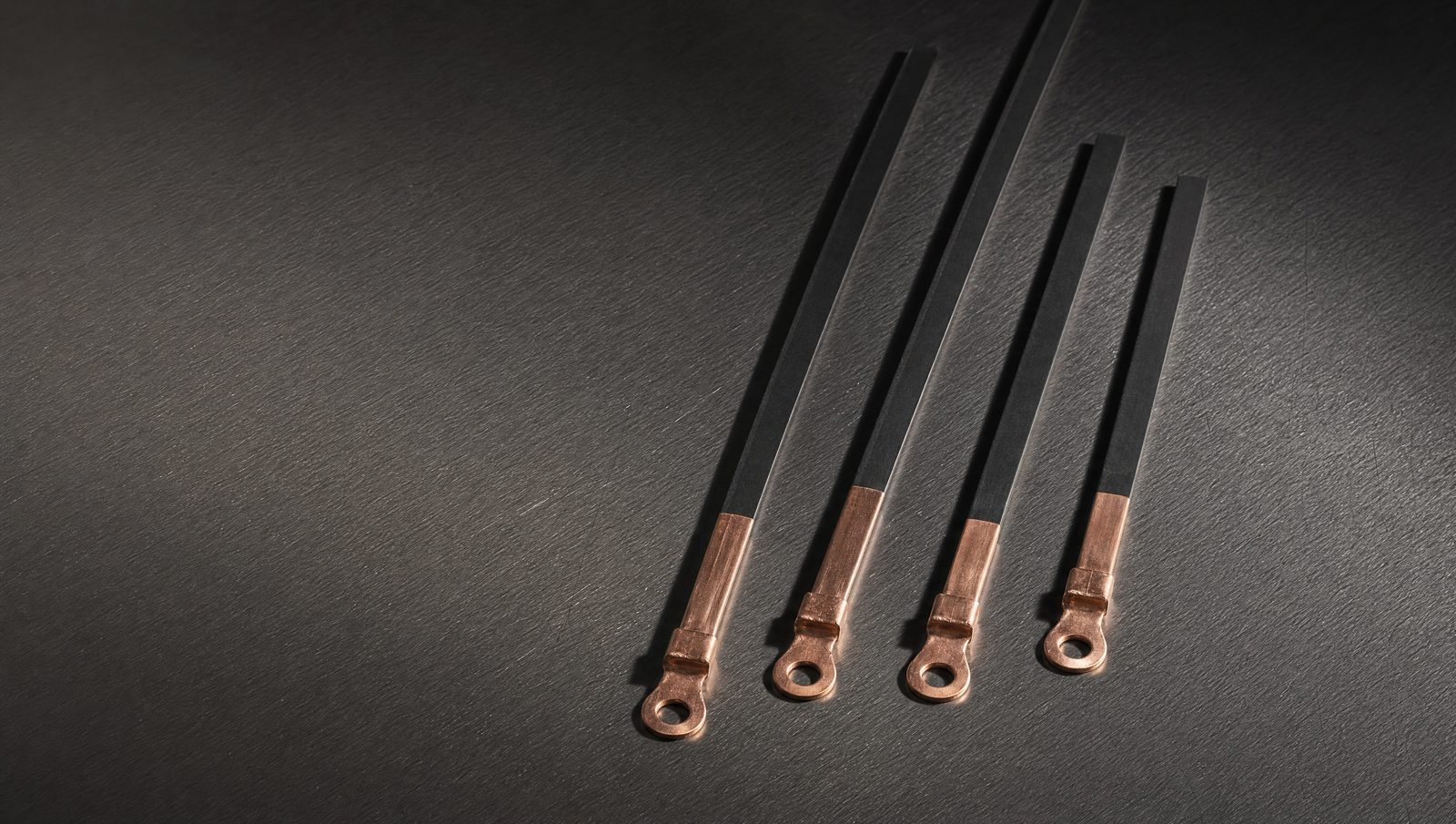 Custom made impulse heat seal elements of different lengths, flat black PTFE coated ribbon with bright copper ring terminals.